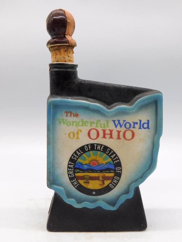 Jim Beam Wonderful World of Ohio: A Jim Beam decanter molded in the shape of the state of Ohio, lettered The Wonderful World of Ohio and bearing the Great Seal of the State of Ohio, finished in black glaze with a cork stopper. Approxi