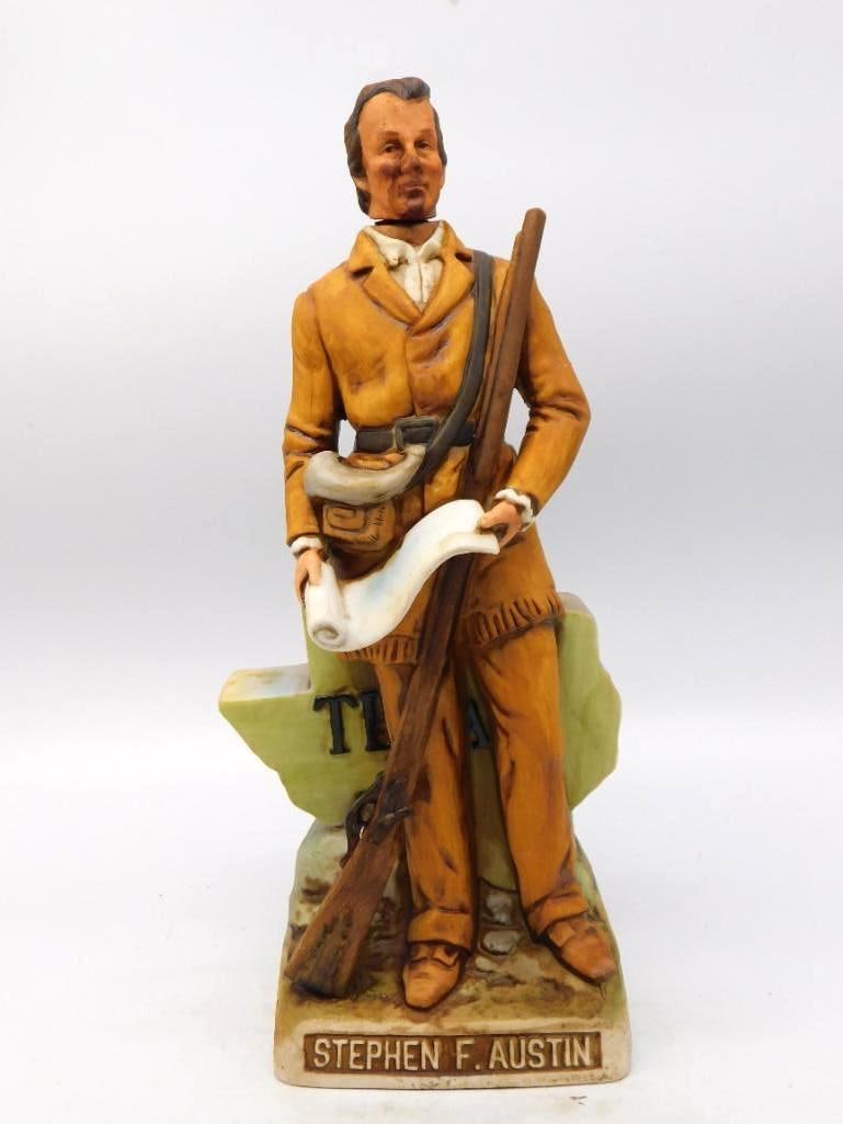 Stephen F. Austin Texas Comm. Ceramic: A stately ceramic decanter modeled as Stephen F. Austin, the empresario shown in a buckskin-trimmed coat with a long rifle at his side and a land grant unrolled in his hand. He leans upon a molded