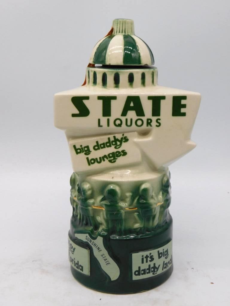Florida Big Daddy's Lounges State: An uncommon advertising decanter shaped as a domed capitol building, lettered State Liquors and Big Daddy's Lounges above a modeled frieze of patrons ranged around a bar. The base carries the
