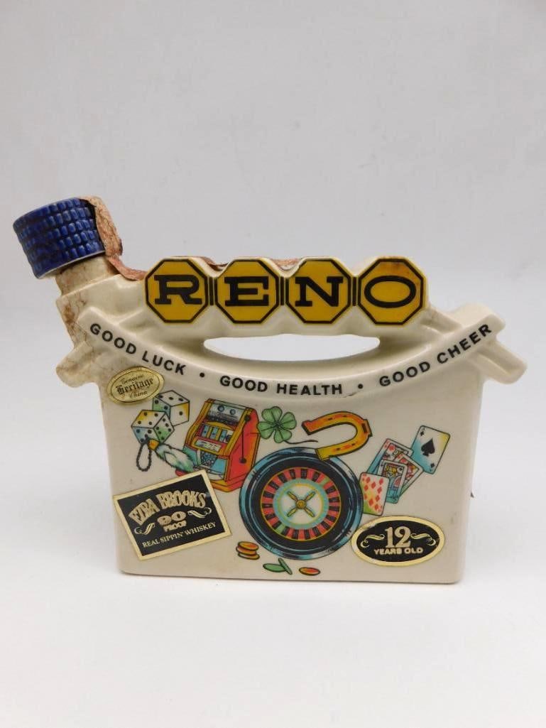 Ezra Brooks Reno Casino Whiskey Jug: An Ezra Brooks 12-year-old Heritage China jug decanter on the Reno theme, lettered Reno - Good Luck, Good Health, Good Cheer and graphic with dice, cards, and a roulette wheel. The base is dated