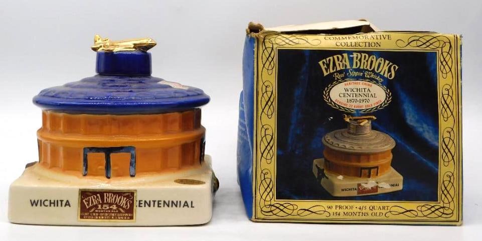 Ezra Brooks Wichita Centennial 1870-1970: An Ezra Brooks Heritage China decanter modeled as a domed Wichita landmark in cobalt and amber, a gold airplane perched atop for a stopper. WICHITA CENTENNIAL runs boldly across the white plinth and