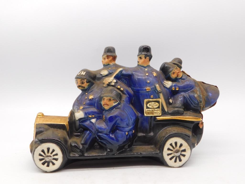 Jim Beam Keystone Kops Car Decanter: A Jim Beam Regal China decanter modeled as a vintage motorcar packed with helmeted "Keystone Kops" police officers in blue uniforms, a whimsical tribute to the silent-film comedy troupe. See photos