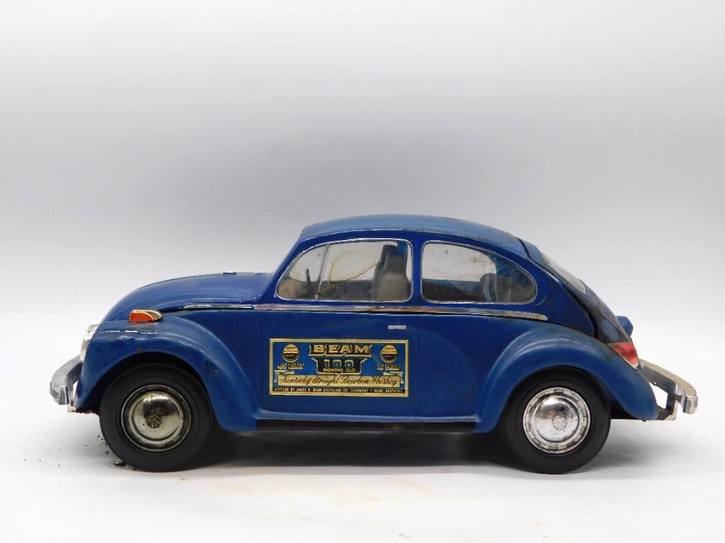 Jim Beam Blue Volkswagen Beetle Decanter: A Jim Beam decanter cast in the form of a blue Volkswagen Beetle, with chrome-look bumpers and hubcaps and a Beam Kentucky Straight Bourbon Whiskey label upon the door. Approximately 12 inches long.