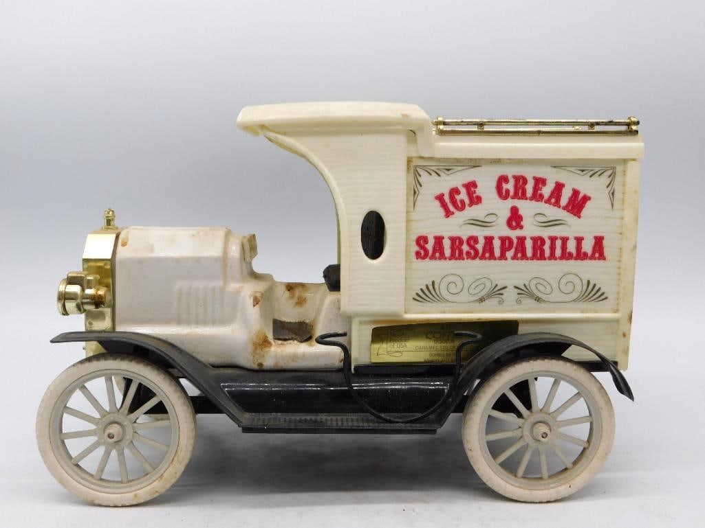 Ice Cream and Sarsaparilla Delivery: A genial decanter modeled as an early open-cab delivery truck, the cream-painted van lettered ICE CREAM & SARSAPARILLA in red with scrolled flourishes below. Brass lamps, radiator, and roof rail set o