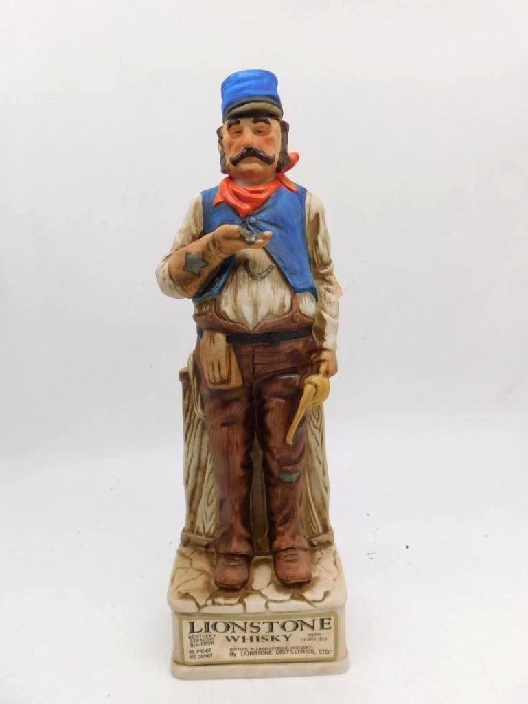Lionstone Railroad Man Decanter with: A Lionstone Kentucky Straight Bourbon Whiskey porcelain decanter modeled as a railroad man in a blue vest and orange bandana, a star badge at his breast and tools in hand, standing beside a wooden
