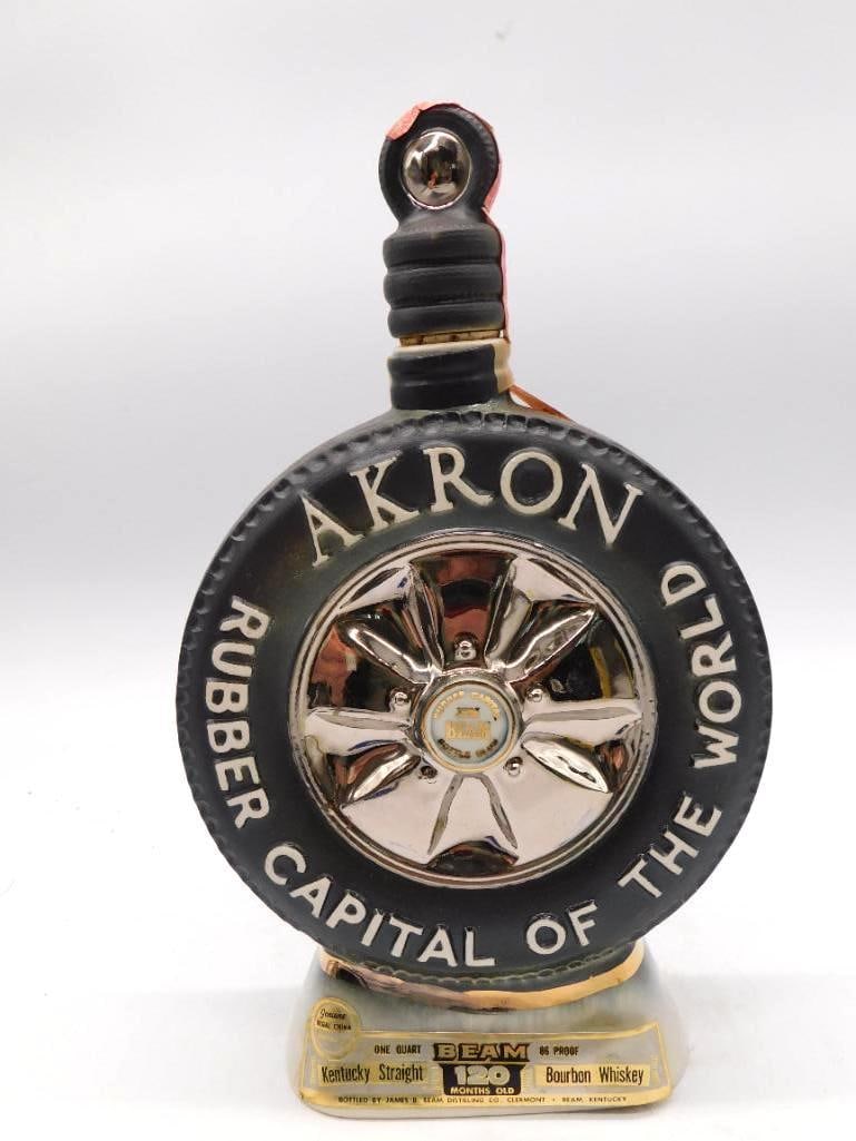 Jim Beam Akron Rubber Capital of the: A Jim Beam ceramic decanter molded as a black-and-white sidewall tire with a chrome-look hubcap at its center, lettered Akron, Rubber Capital of the World. Carries the Kentucky Straight Bourbon