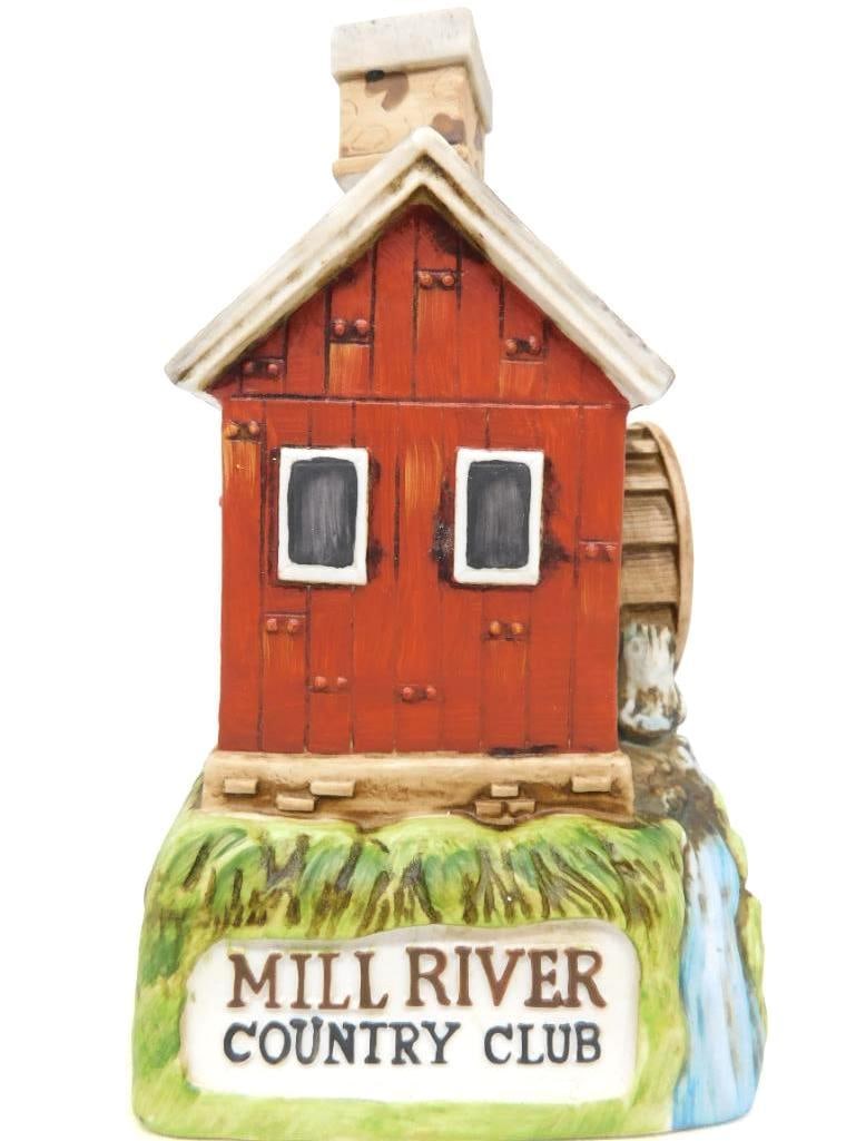 Ski Country Mill River Country Club Old: A Ski Country decanter modeled as a red clapboard water mill, its wheel standing beside a falling stream and the green bank lettered Mill River Country Club across the front. The painting is
