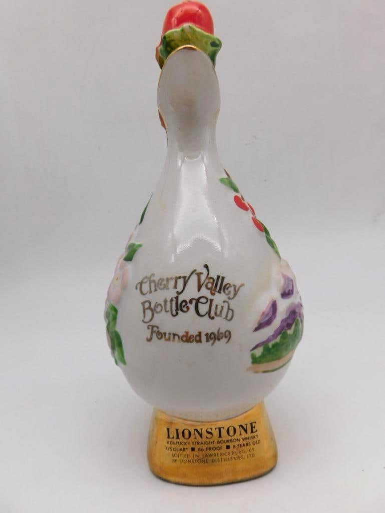 Lionstone Cherry Valley Bottle Club Swan: A Lionstone porcelain decanter in the form of a swan, made for the Cherry Valley Bottle Club and hand-painted with cherries and floral sprays. Fitted with a gold-tone curved handle upon a squared