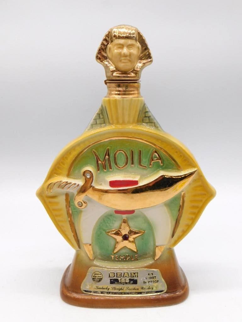 Jim Beam Moila Shrine Temple Shriners: A Jim Beam ceramic decanter made for the Shriners' Moila Temple, bearing a crescent-and-star medallion and topped by a stopper modeled as a fez-wearing head. Marked Kentucky Straight Bourbon Whiskey.