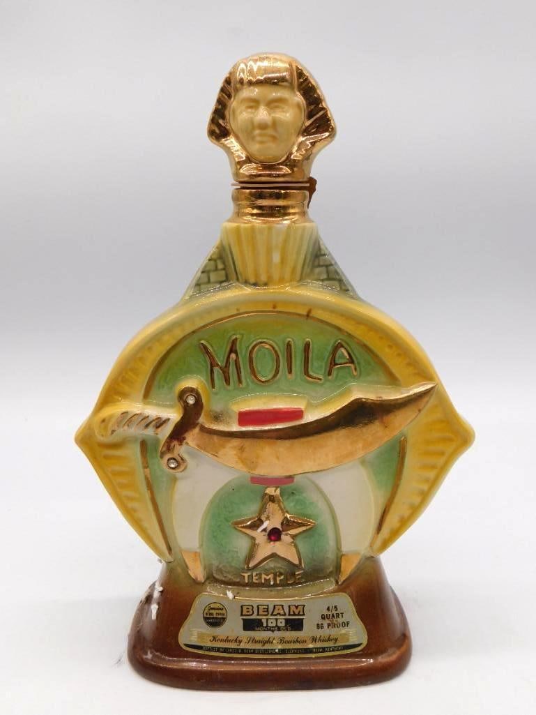 Jim Beam Moila Shrine Temple Shriner: A Jim Beam ceramic decanter honoring the Moila Temple of the Shrine, worked in gold and green with crescent, star, and scimitar medallions to both faces and a sultan-form stopper. Marked Kentucky