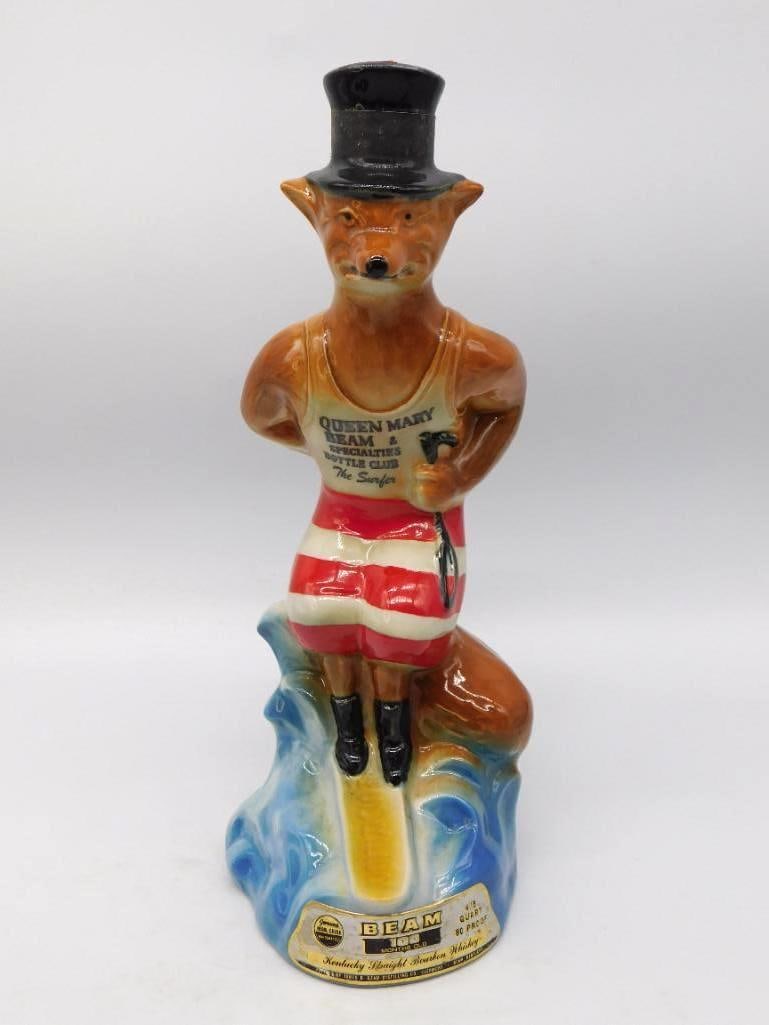 Jim Beam Queen Mary Beam and Specialties: A spirited Jim Beam club decanter modeled as a fox standing in a striped bathing costume with a black top hat for a stopper, breasting a blue cresting wave. The vest reads Queen Mary Beam and Specialt