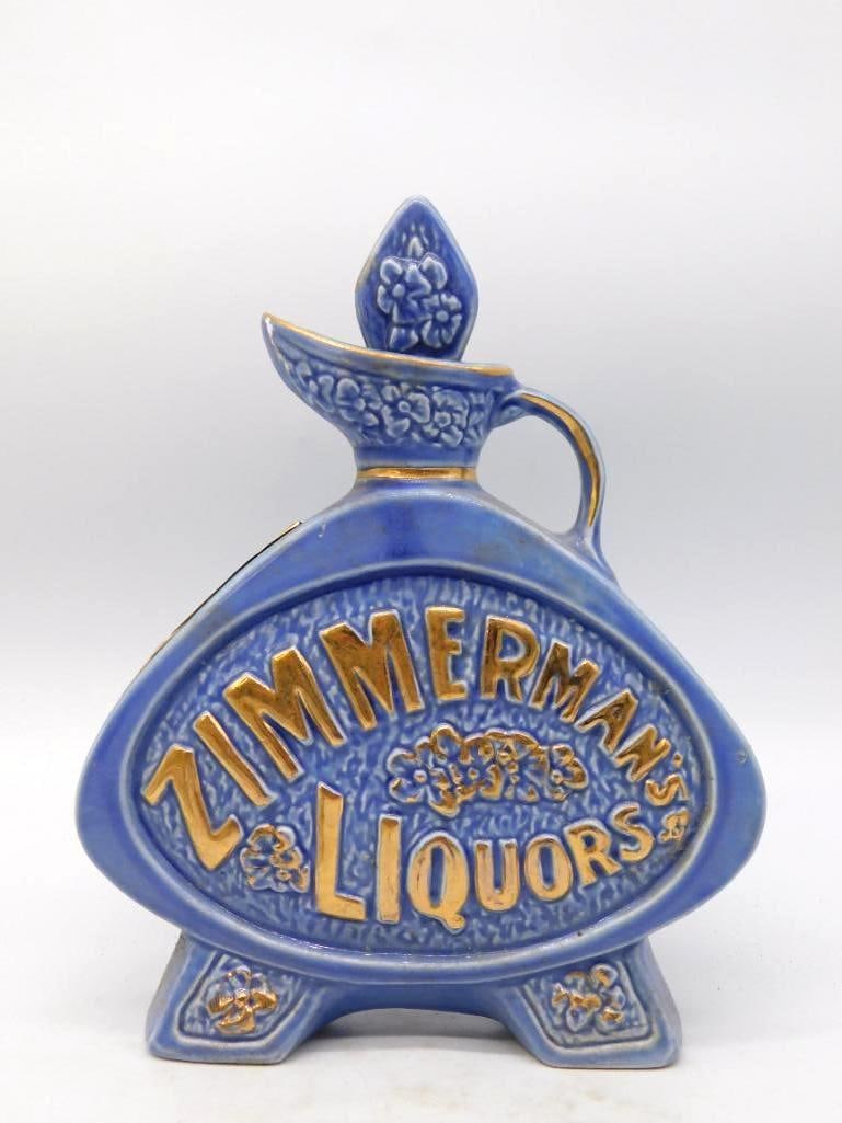 Jim Beam Zimmerman's Liquors Blue and: A handsome Jim Beam Regal China jug in mottled cobalt blue, its face raised and gilded with the legend Zimmerman's Liquors above a spray of blossoms. Three stout feet and a ribbed handle carry the