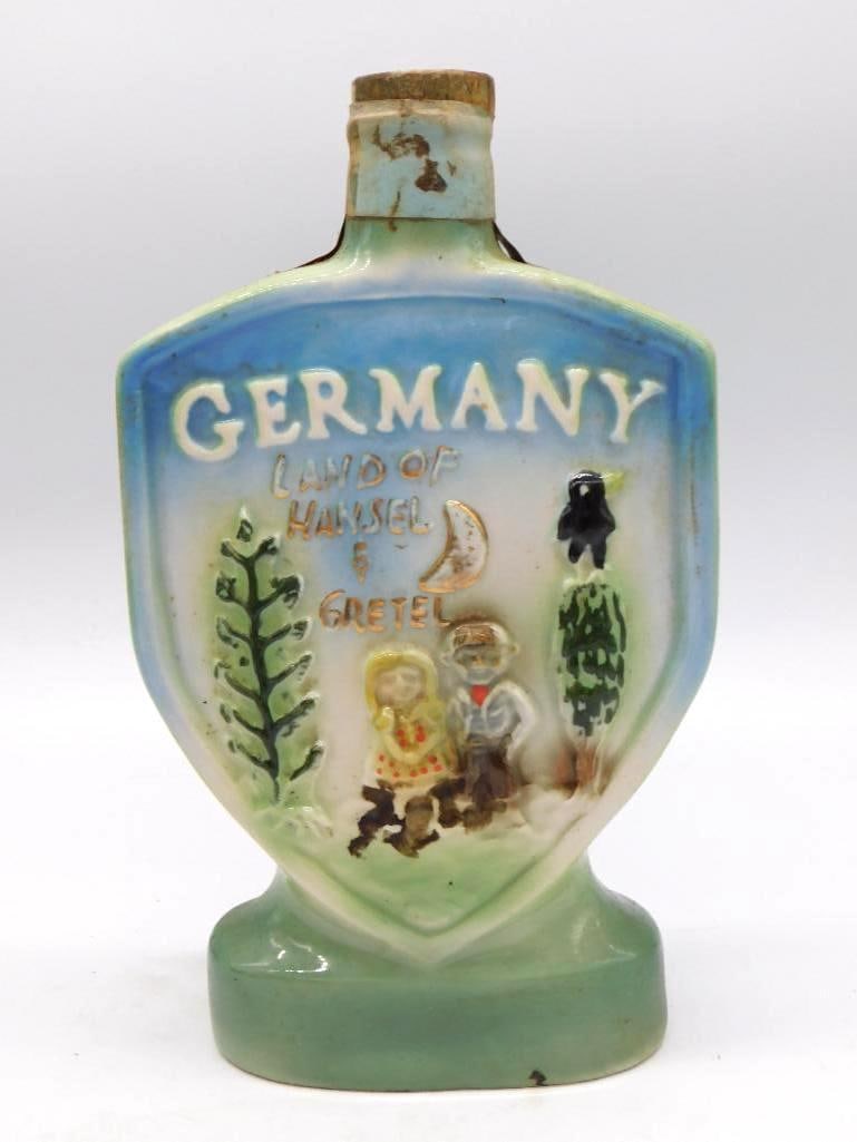 German Porcelain Land of Hansel and: A hand-painted porcelain decanter marked Germany, Land of Hansel and Gretel, its raised fairy-tale cottage scene worked in blue and green. A genial souvenir bottle with cork stopper. Stands