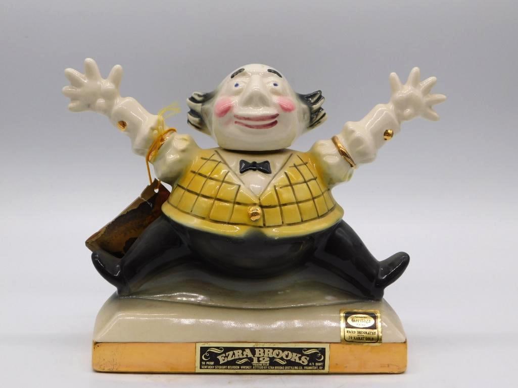 Ezra Brooks 24K Gold Clown Decanter: An Ezra Brooks Heritage China decanter modeled as a smiling clown with arms flung upward, hand-decorated with 24 karat gold accents. A lively subject, brightly finished. Labeled Kentucky Straight