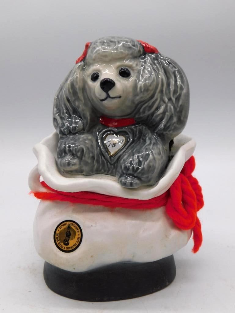 Jim Beam Tiffiny Poodle Dog Decanter: A whimsical Jim Beam decanter modeled as a gray poodle in a white cap trimmed with red yarn. A paper label names her Tiffiny and refers to the National Association of Bottle & Specialties Clubs, with
