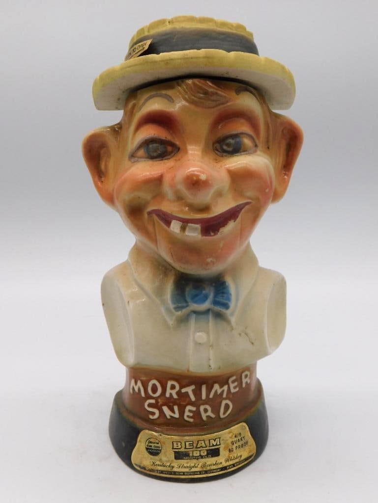 Jim Beam Mortimer Snerd Character: A Jim Beam ceramic decanter modeled as Mortimer Snerd, the country-bumpkin dummy of Edgar Bergen, in cream and tan beneath a yellow straw hat. The comical face is well caught, and the sculptor