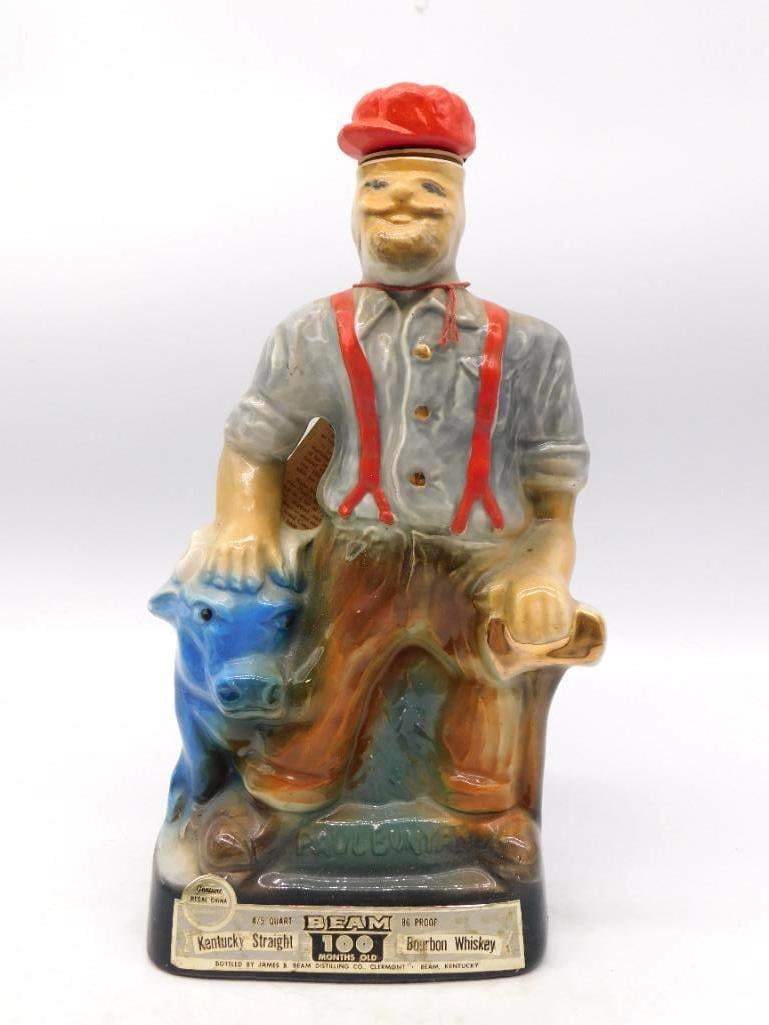 Jim Beam Paul Bunyan Brainerd Minnesota: A hearty Jim Beam Regal China decanter modeled as Paul Bunyan seated at his rest, the blue ox at his knee and a stand of timber behind him. The base carries the Brainerd, Minnesota Centennial
