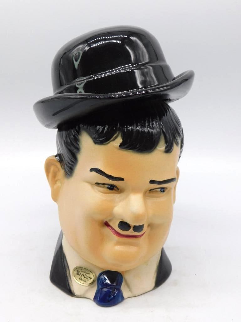 Heritage China Bowler-Hatted Gentleman: A character bust decanter modeled as a stout gentleman in a glossy black bowler, with clipped mustache and blue bow tie, the hat lifting away to serve as the stopper. The painter gave him a warm and