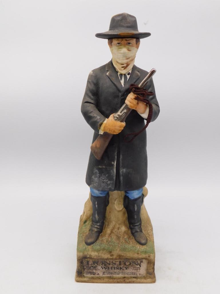 Trench Coat Detective Figural Decanter: A hand-painted decanter modeled as a man in a long trench coat and fedora, hands tucked in his pockets, evoking a classic film-noir detective. No maker's mark is visible in the photos provided. See