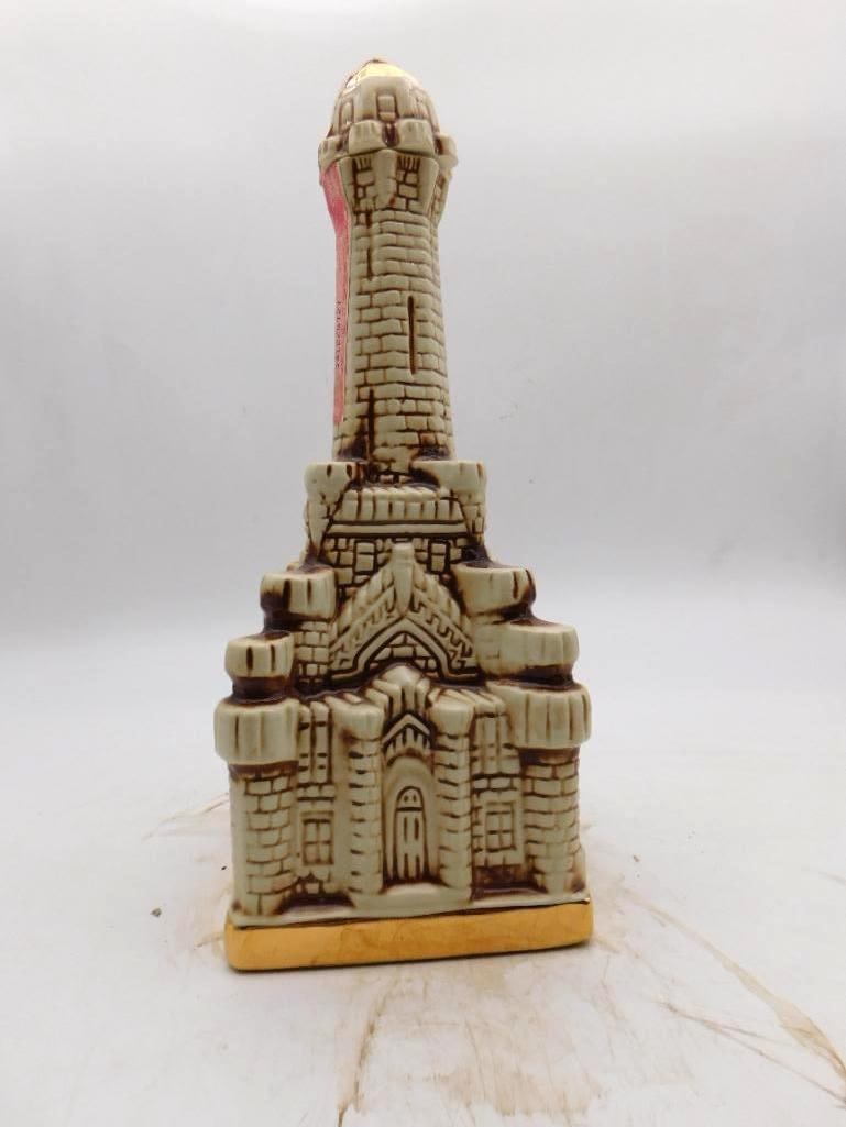 Ezra Brooks Castle Tower Decanter, 12: An Ezra Brooks 12 Years Old ceramic decanter modeled as a stone castle with a tall central turret upon a gilt-trimmed base. Stately in line and taller on the shelf than one expects. Good vintage