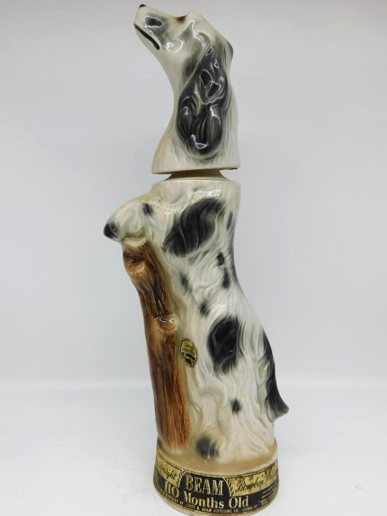 Jim Beam English Setter Dog Regal China: A Jim Beam Regal China decanter modeled as a black and white English Setter seated beside a tree stump, the head lifting away to serve as the stopper. Labeled Kentucky Straight Bourbon Whiskey, 110