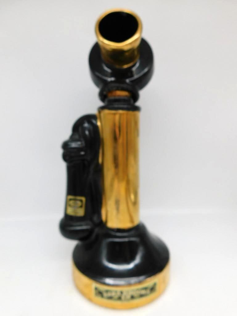 Ezra Brooks Heritage China Candlestick: An Ezra Brooks Heritage China decanter styled as an antique candlestick telephone in black and gold, the receiver hung at its side. A singular shape, and cleanly cast. Approximately 11.5 inches tall, 