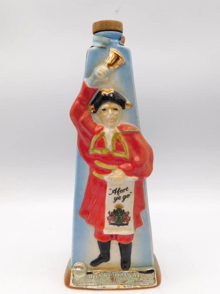 Bell's Royal Vat Scotch Whiskey Town: A Bell's Royal Vat scotch whiskey decanter modeled as a town crier ringing his bell, a scroll in hand reading Afore Ye Go. A character piece with genuine presence. Ceramic, 13 years old, 4/5 quart, 86