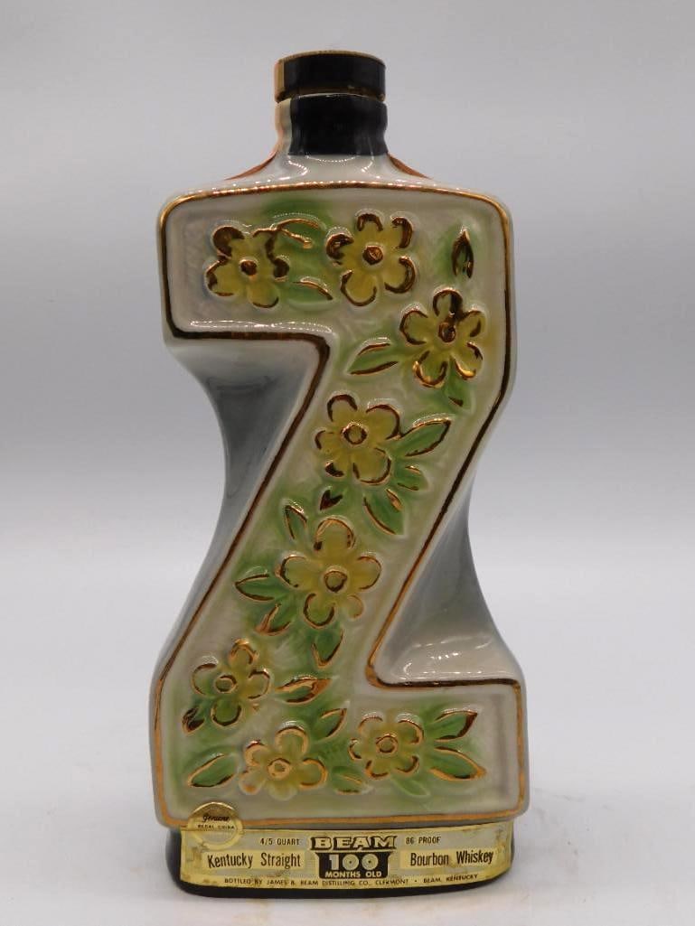 Jim Beam Green and Gold Floral Ceramic: A cream ceramic Jim Beam decanter of angular novelty form, dressed with raised yellow and green floral sprays picked out in gold. A trim and decorative piece for the sideboard. Carries the Kentucky