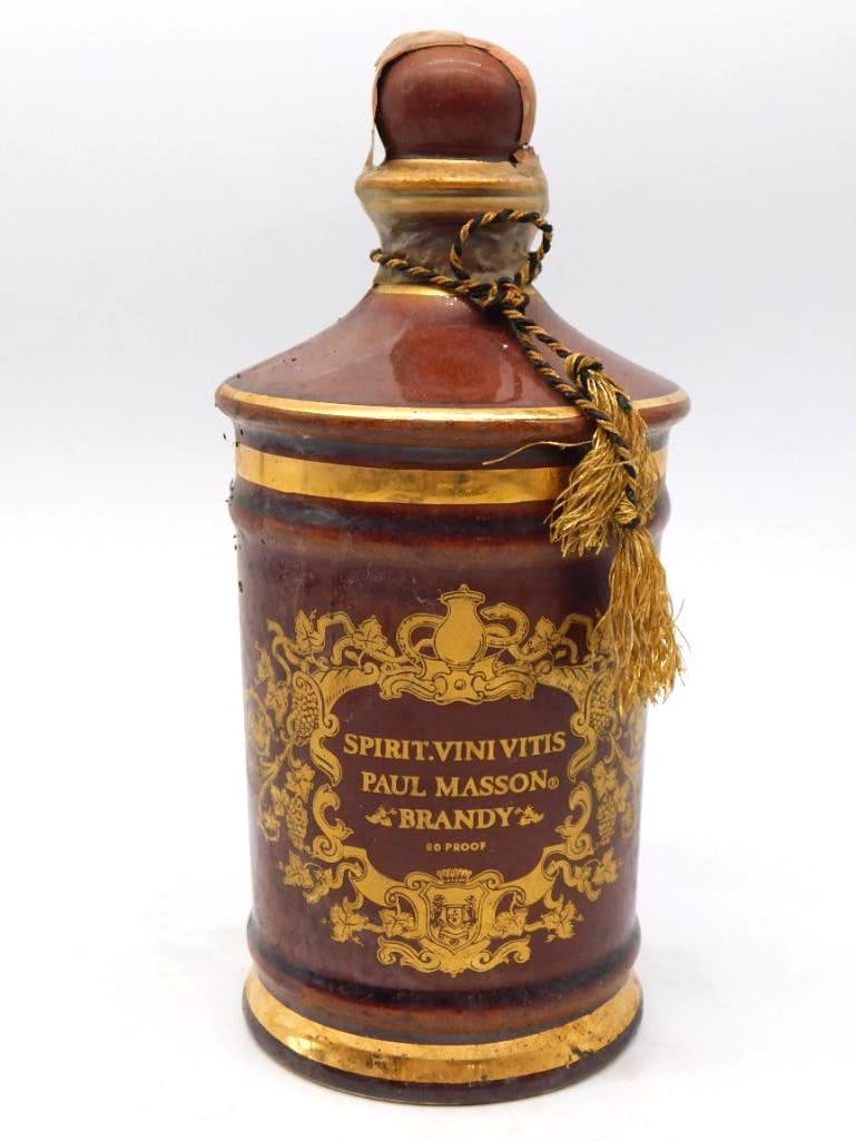 Paul Masson Brandy Ceramic Decanter with: A well-turned Paul Masson decanter in the form of an apothecary jar, glazed a deep oxblood brown and banded in gold about the shoulder and foot. The front carries a gilt cartouche lettered Spirit