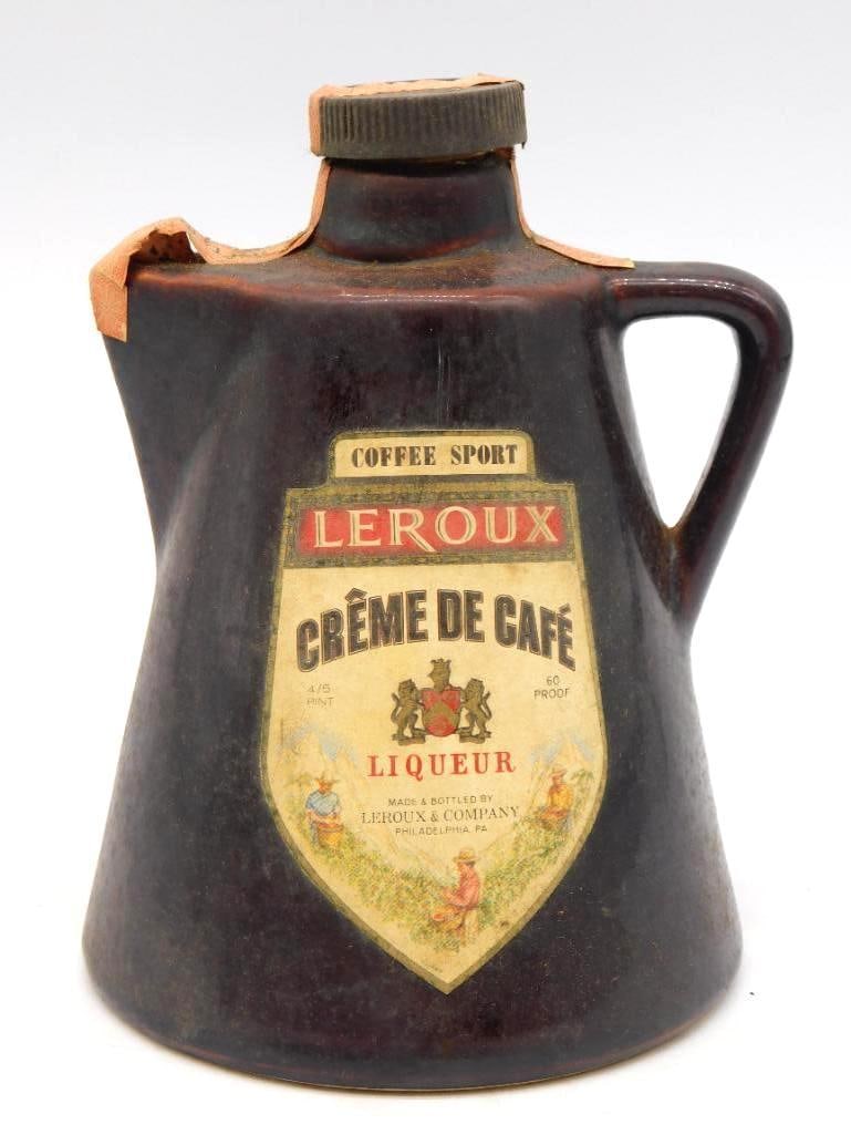 Leroux Creme de Cafe Coffee Sport Brown: A homespun Leroux liqueur jug in deep brown glaze, stoutly potted with a loop handle and a broad sloping shoulder. The shield label is a fetching bit of printing, showing coffee pickers at work