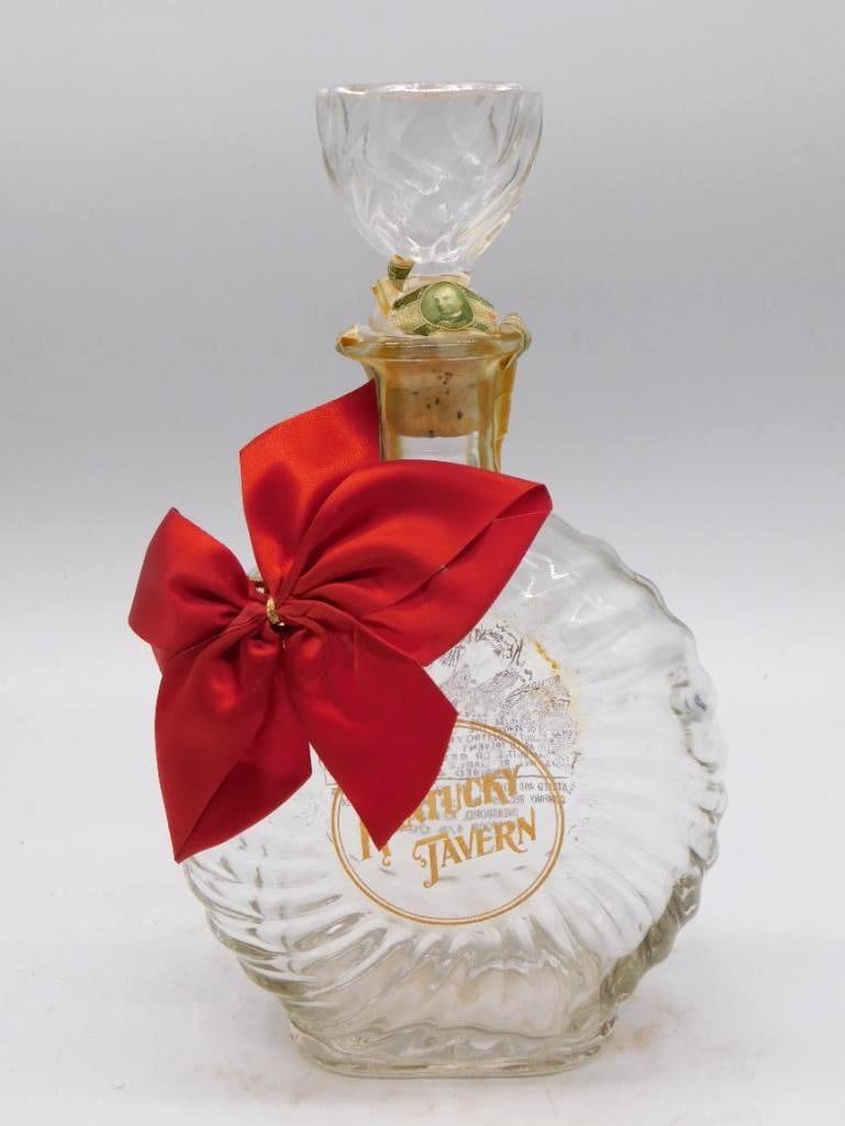 Kentucky Tavern Cut Glass Decanter with: A clear cut-glass whiskey decanter for Kentucky Tavern, its scalloped stopper and original cork both present, with a red satin ribbon tied at the neck. Stands approximately 10 inches tall, and the cut