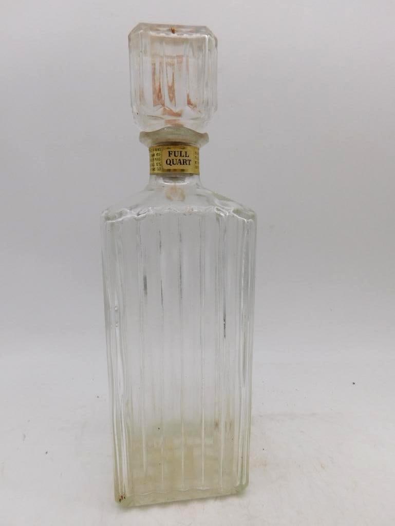 Ribbed Clear Glass Decanter with Stopper: A trim clear glass decanter of squared form, its sides cut in close vertical ribs that catch the light, fitted with a faceted glass stopper. Plain and workmanlike, and honest enough for any sideboard.