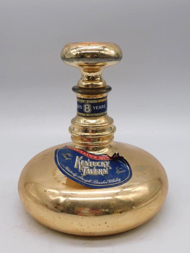 Kentucky Tavern Gold-Tone Modernist: A Kentucky Tavern decanter in a rounded modernist form under a gold-tone glaze, handsome and unfussy. The label reads Aged 8 Years, 90 Proof, Kentucky Straight Bourbon Whiskey. Measures approximately