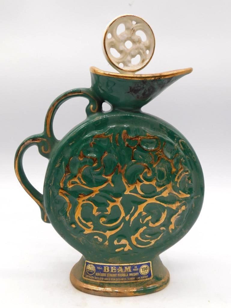 Jim Beam Green Drip Glaze Ewer Decanter: A Jim Beam decanter in ewer form beneath a green and gold drip glaze, with an open handle and a pierced white ceramic medallion stopper. The glaze runs handsomely and the shape is well-turned. The bas