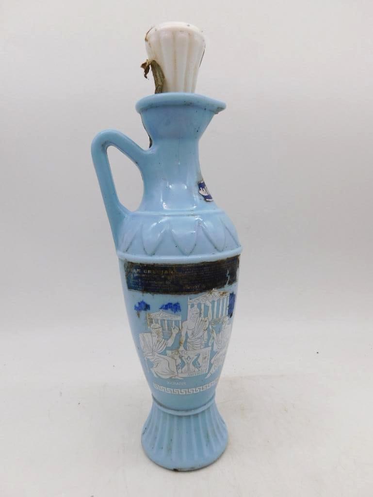 Jim Beam Grecian Blue Milk Glass Ewer: An agreeable Jim Beam ewer in pale blue milk glass, single-handled and footed, the body printed with white-robed philosophers among temple columns above a Greek key border. The white stopper is