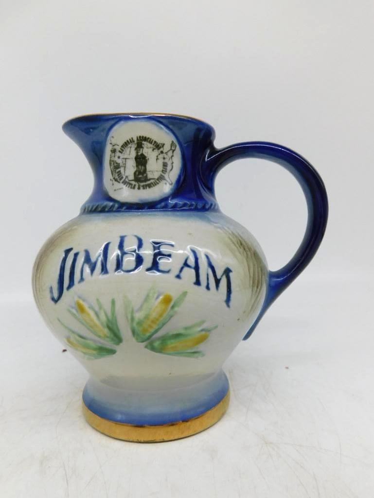 Jim Beam Bottle Club Pitcher Decanter in: A capital little Jim Beam pitcher in cobalt and cream, the belly lettered Jim Beam above hand-painted ears of corn, with a gilt band about the foot. The spout carries the medallion of the National