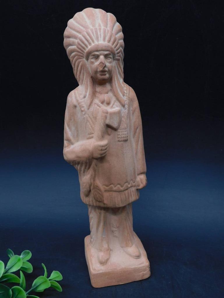 Terracotta Figurine of a Native American Chief: Terracotta figurine depicting a Native American chief wearing a traditional headdress. Features detailed carvings and stands upright on a rectangular base. The statue showcases intricate details in th