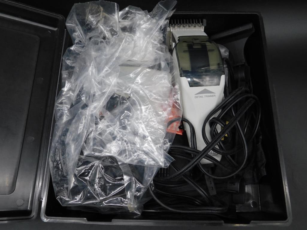 Wahl Electric Detail Hair Trimmer in Case: Wahl electric detail trimmer with a plastic case. Includes trimmer unit, power cord, and additional cutting accessories stored in plastic bags. Designed for precision trimming and grooming. Case is
