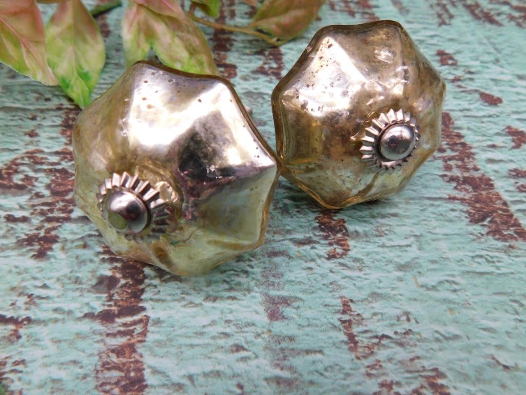 Gold-Toned Decorative Furniture Knobs With Sunburst Detail: Set of two decorative furniture knobs with a gold-toned finish. Designed with a sunburst pattern around a silver-toned central stud. Each piece is equipped with a threaded screw for easy attachment.