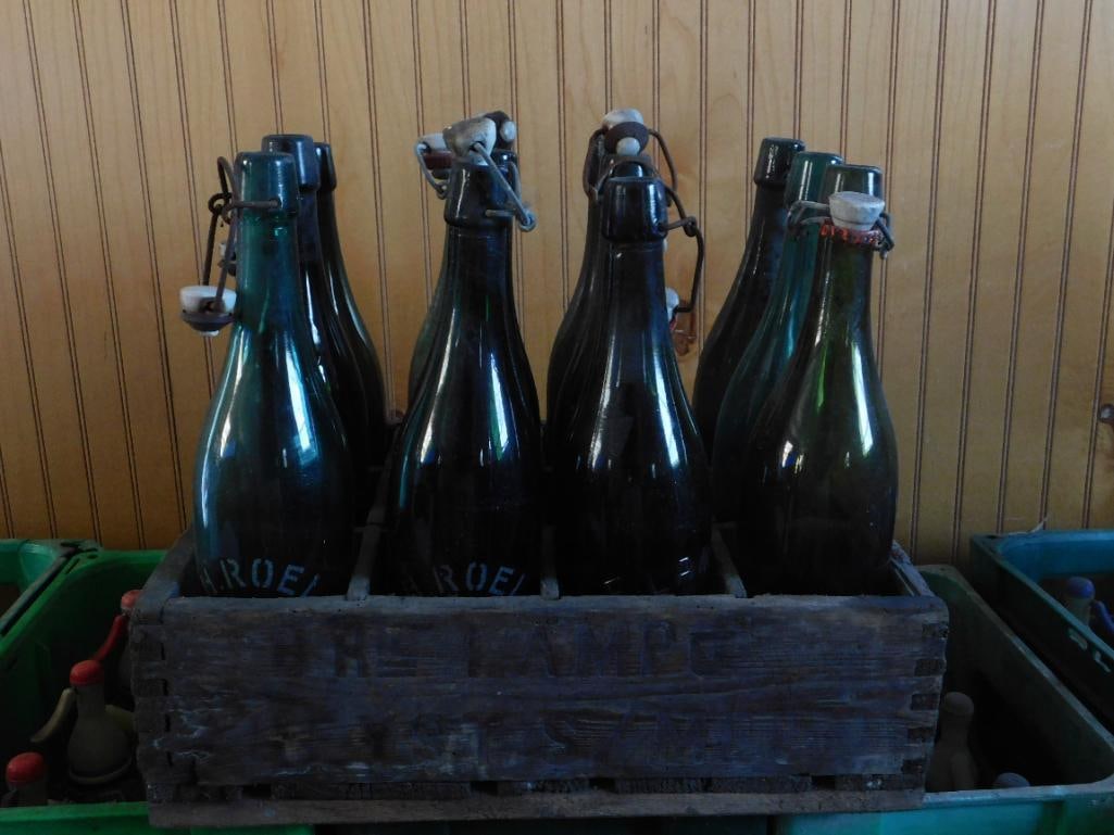 Antique: Belgian Glass Swing-Top Bottles in Wood Crate: Set of eight antique dark green glass swing-top (Bugelverschluss style) bottles, several retaining their original ceramic and wire flip-top stoppers, embossed "CH. ROELS" with additional stenciled num