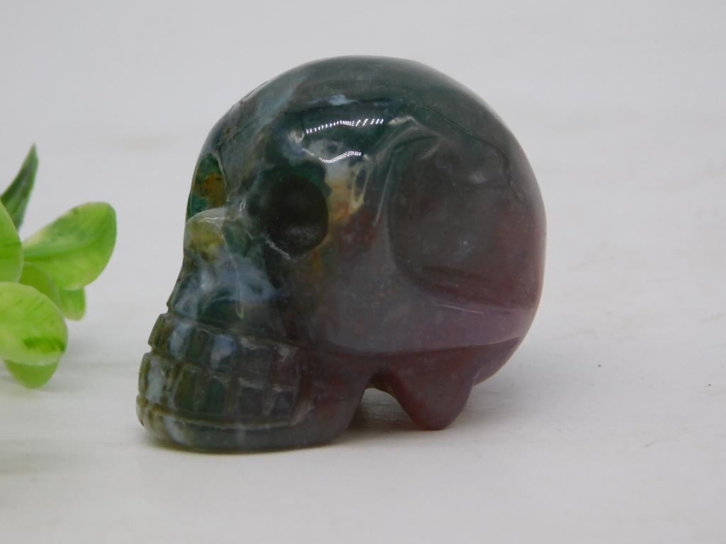 Skull Carved Bloodstone Gemstone Figurine 44g: Small hand-carved gemstone skull in bloodstone (green with red inclusions), polished to a high gloss. Weighs 44 grams and measures approximately 2 inches long, shown beside a quarter for scale. Detail