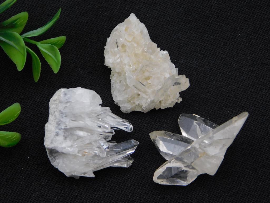 Crystal Cluster Lot - Three Natural Quartz Specimens: Group of three natural quartz crystal specimens: a clear quartz point cluster, a tan-tinted crystal cluster on a small matrix base, and a smaller clear quartz crystal point formation. The lot tag