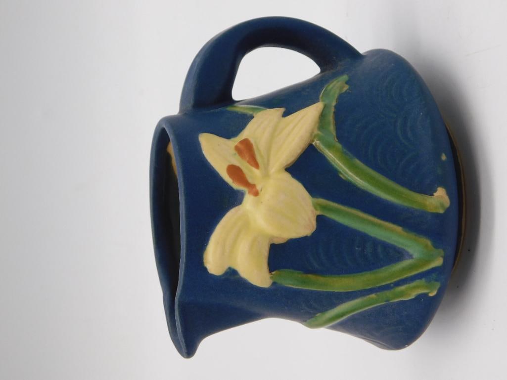 Pottery - Roseville Freesia Blue Creamer/Mug, Marked Roseville 7-C: A cobalt blue Roseville pottery creamer or handled mug decorated with a raised yellow and orange freesia flower and green leaves against a textured wave-pattern ground. The base is impressed "Rosevill