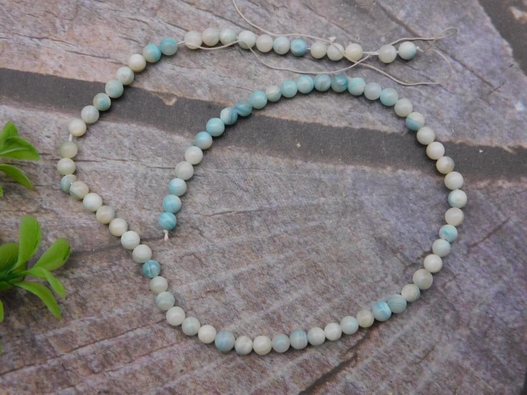 Necklace - Blue Banded Agate Bead Strand, 28 Inches: Single-strand beaded necklace of round beads with blue, gray, and cream marbled/banded coloring resembling blue lace agate or dyed banded agate. Uniform beads roughly 8mm in diameter, strung on cord w