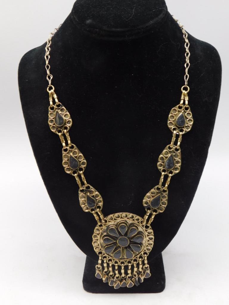 Necklace - Ornate Gold-Tone Filigree Pendant, Boho Style: Statement necklace in antiqued gold-tone metal with ornate filigree link stations set with dark cabochon stones, centering on a round floral medallion pendant with dangling drops. Measures approximate