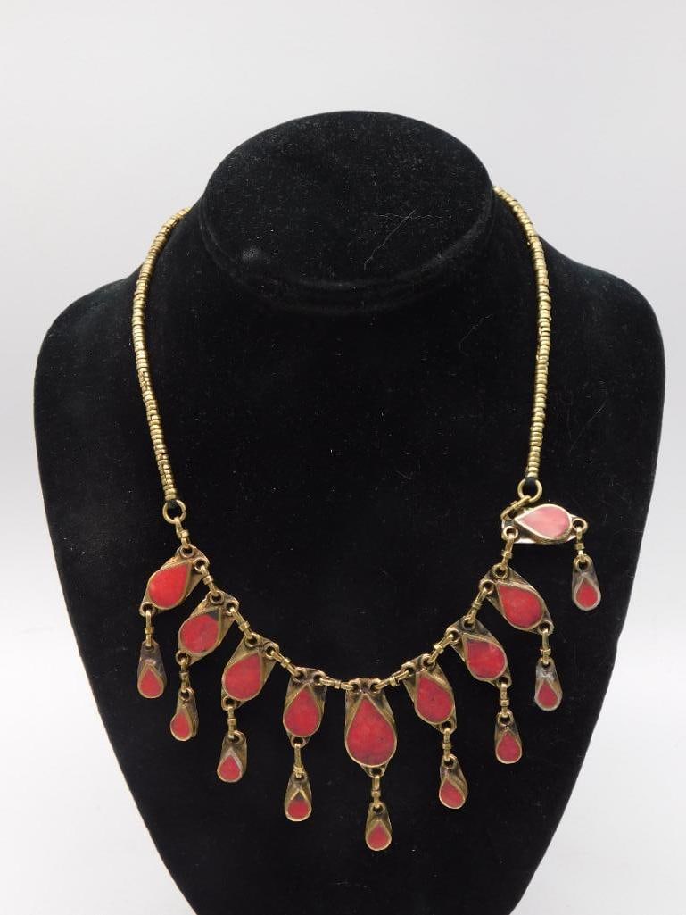 Necklace - Tribal Brass Bib with Red Glass Dangles: Vintage tribal-style bib necklace with a brass/gold-tone beaded collar and a fringe of red glass or coral-composite teardrop dangles. Measures approximately 17 inches long based on ruler comparison. E