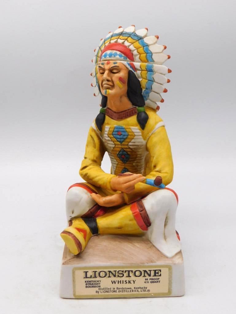 Lionstone Tribal Chief 1800-1870: A Lionstone decanter modeled as a seated tribal chief in a full feathered war bonnet, a pipe held across his lap. The painter gave particular care to the beaded shirt front and the tipped quills of