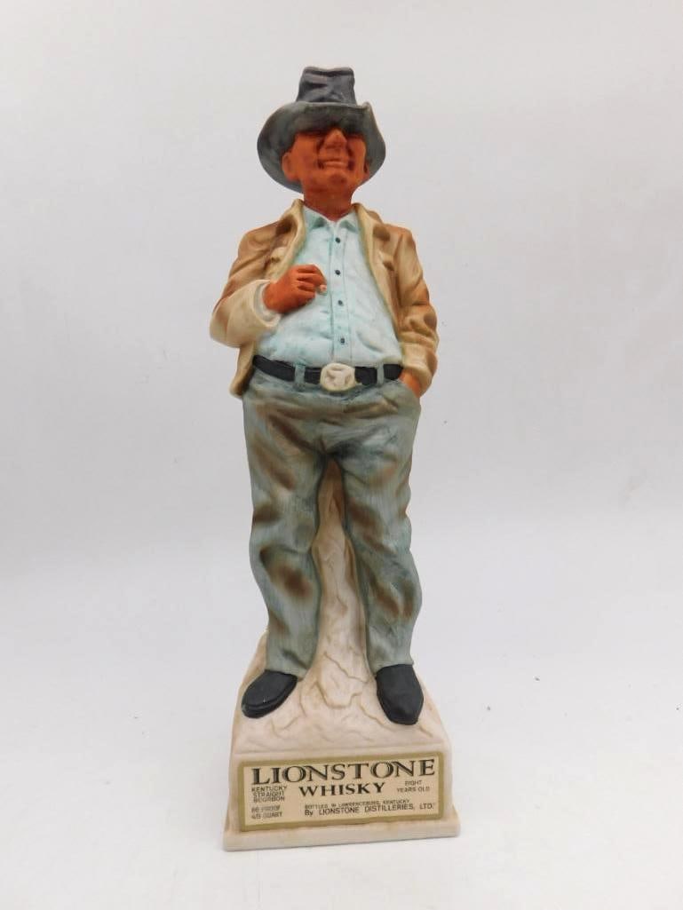Lionstone Standing Cowboy Western: A Lionstone porcelain decanter sculpted as a cowboy standing at ease in a tan jacket and gray hat, hands in his pockets, upon a rocky base. Labeled Lionstone Kentucky Straight Bourbon Whiskey. The