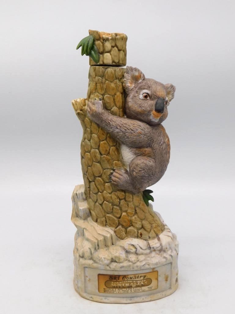 Ski Country Australian Koala Climbing a: A Ski Country decanter modeled as an Australian koala clinging to a tree trunk, the stopper formed as the broken top of the bole. The fur is finely tooled and softly painted, and the sculptor caught a