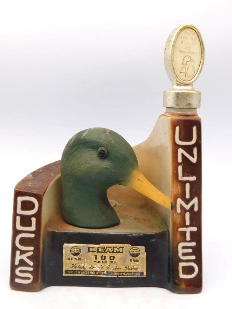 Jim Beam Ducks Unlimited 1978 Mallard Drake Decanter 40th Anniversary: A Jim Beam bottle modeled as a mallard drake's head set within a block lettered Ducks Unlimited the green head and yellow bill rendered with a shrewd eye for the bird. The reverse is glazed a deep wat